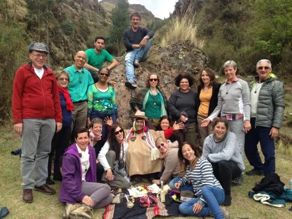 Une vingtaine de participants réunis autour d'une offrande à la Pachamama déposée sur un tissu andin, avec un officiant en tenue traditionnelle.